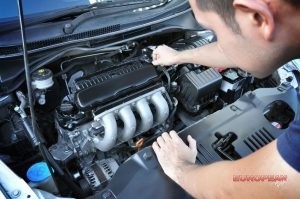 mechanic inspects and repairs car engine