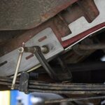 Rust Buster repair parts being installed on to the frame of a vehicle