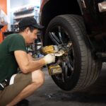 Mechanic inspecting engine bay, showcasing automotive repair skills