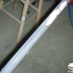Sanding down the car window trim to remove peeling edges and prepare the surface