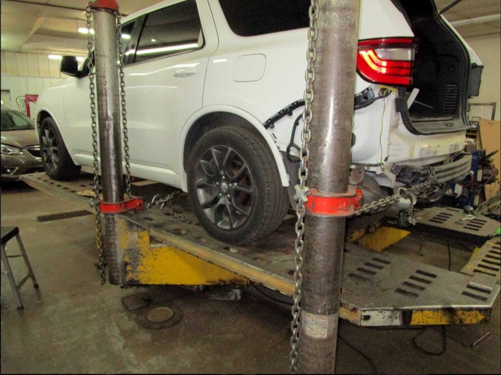 A technician using diagnostic tools on a car engine, showcasing the expertise required in auto repair